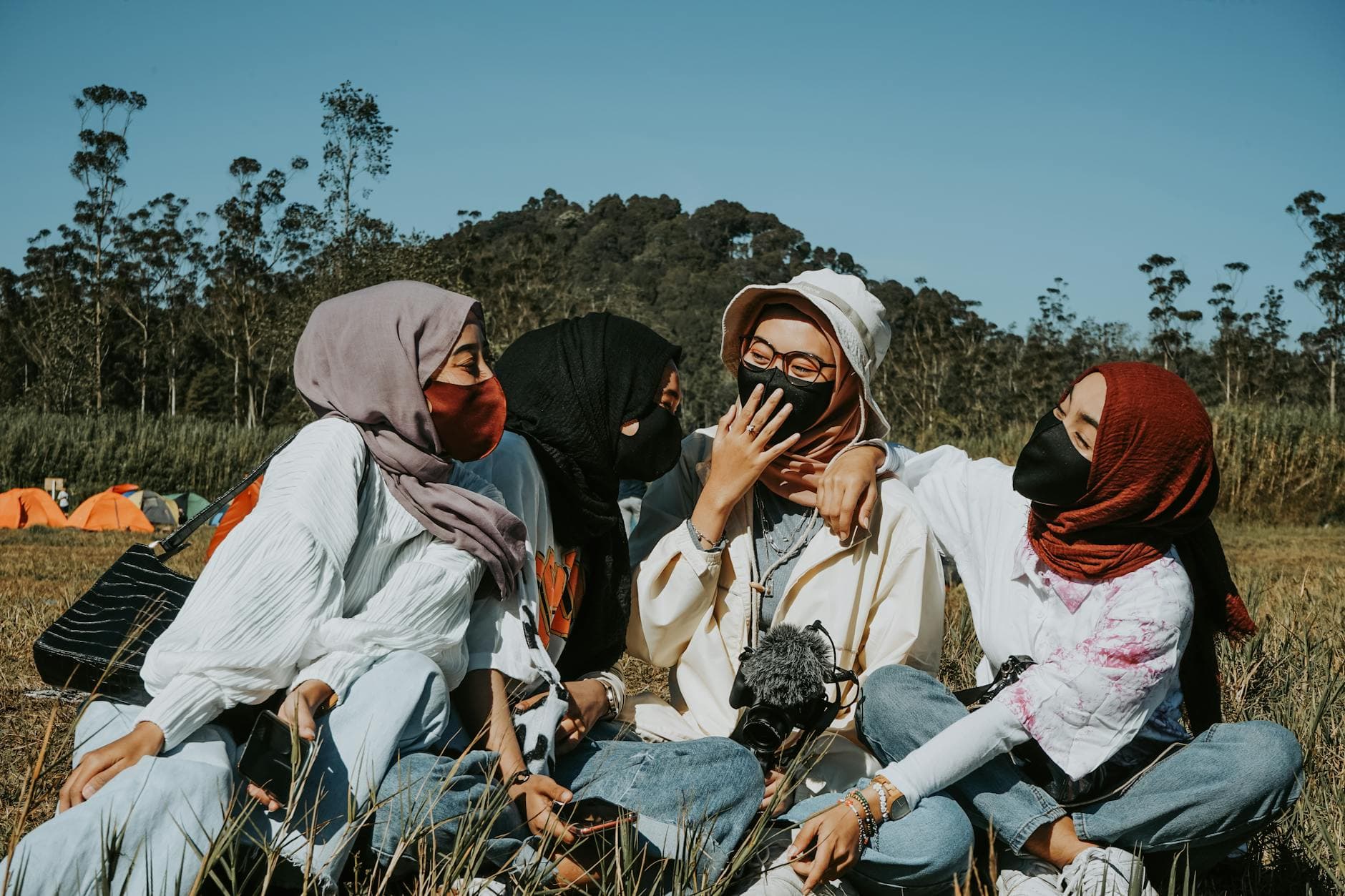 Photo by Labskiii on Pexels A joyful group of women wearing masks and scarves, enjoying time outdoors.