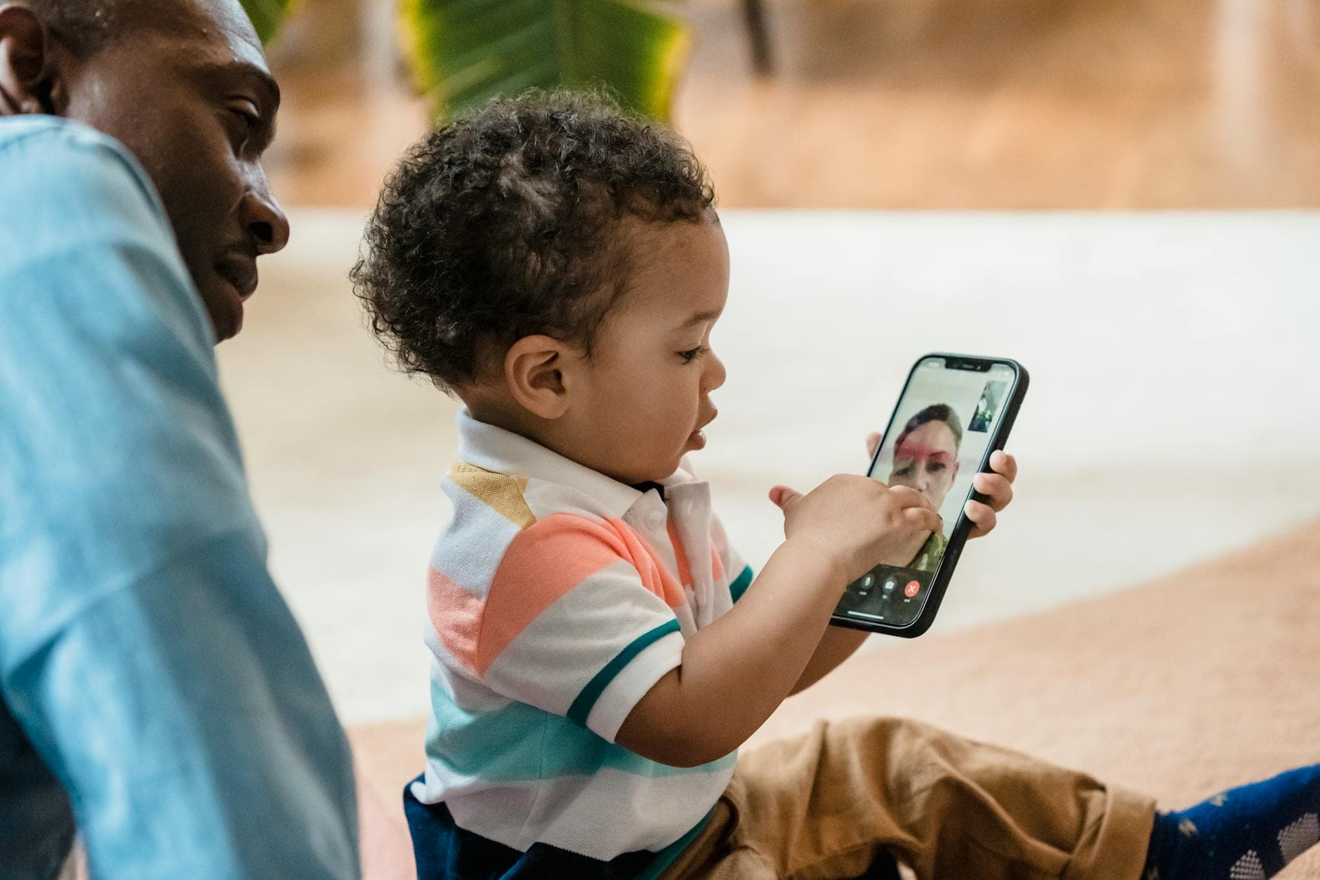 Photo by George Pak on Pexels A child using a smartphone for a video call, learning technology skills indoors.