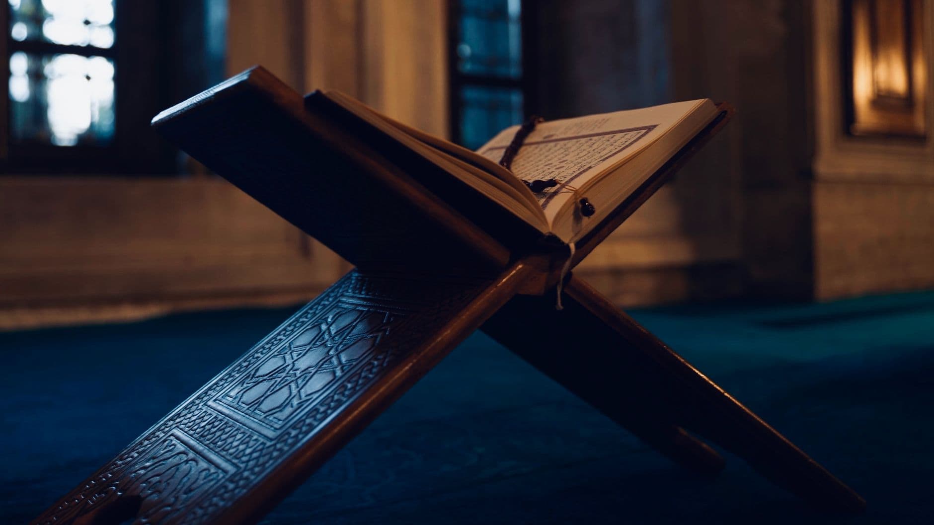 Photo by Pir Sümeyra on Pexels A Quran resting on a wooden stand inside a mosque in Istanbul, captured in soft lighting.