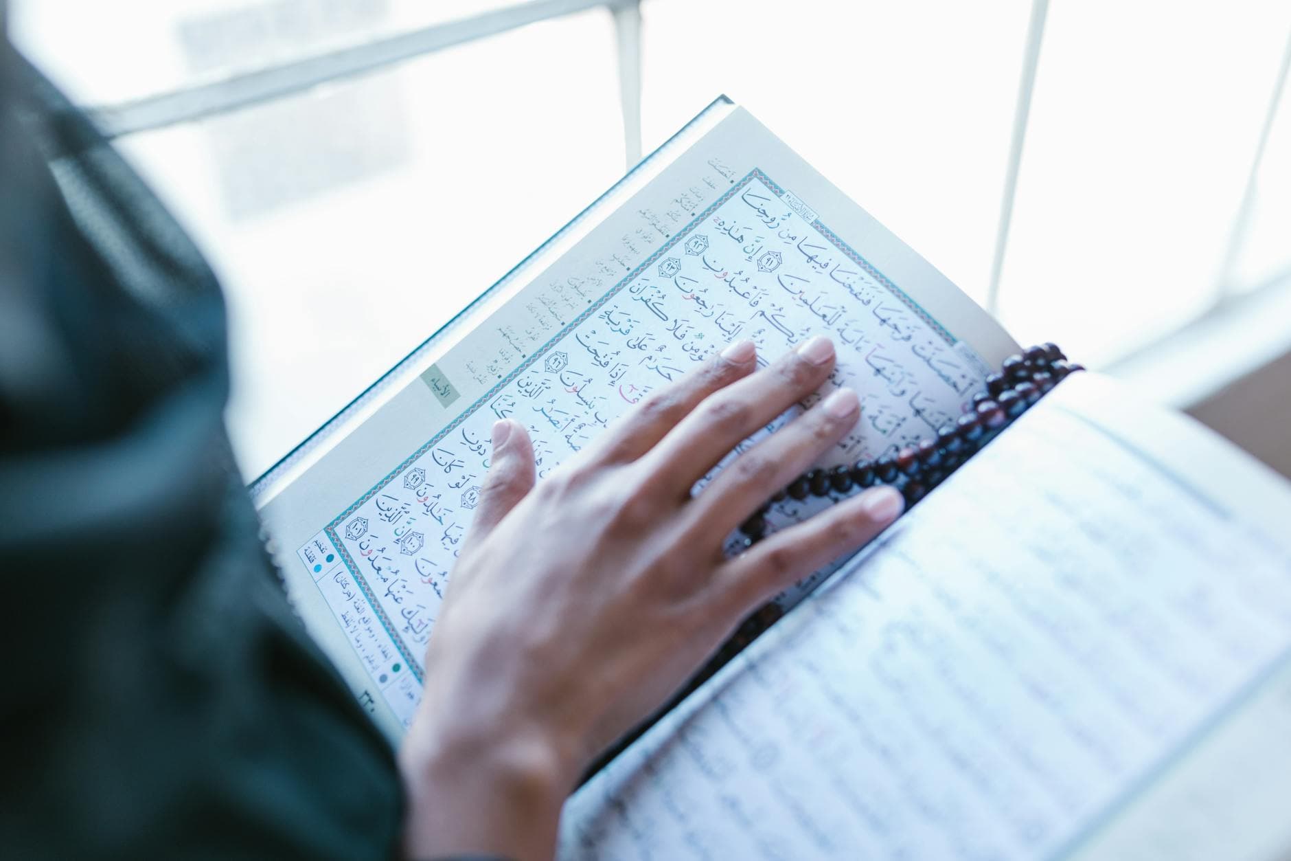 Photo by RDNE Stock project on Pexels A person reading the Quran, highlighting spirituality and worship with prayer beads.