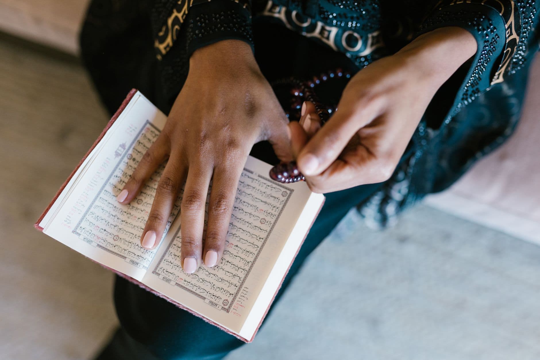 Photo by RDNE Stock project on Pexels Close-up of a woman reading the Quran while holding prayer beads, focusing on spirituality and prayer.