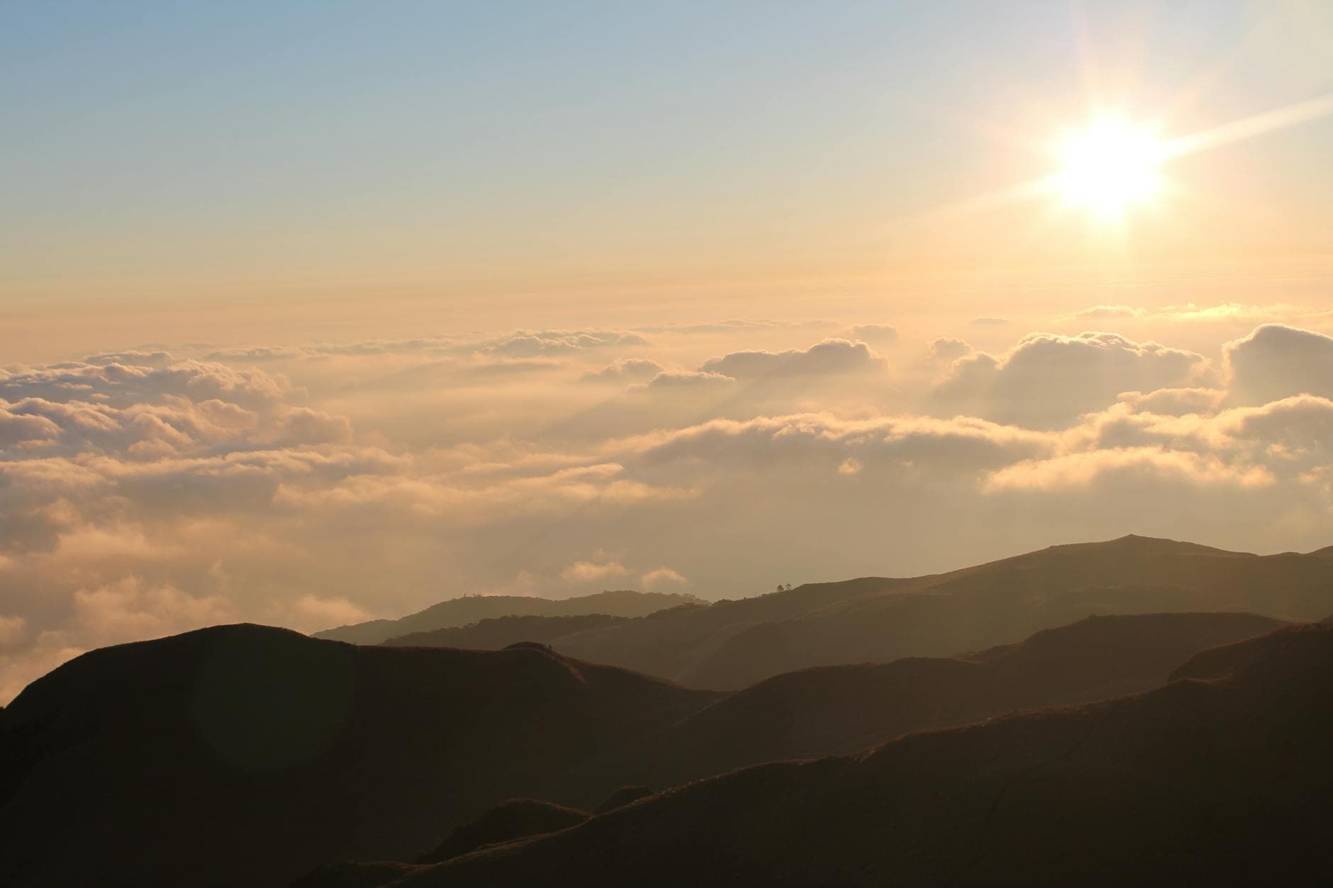 Photo by Dana Ladic on Pexels A breathtaking view of a sunset over rolling hills and clouds, captured from above.