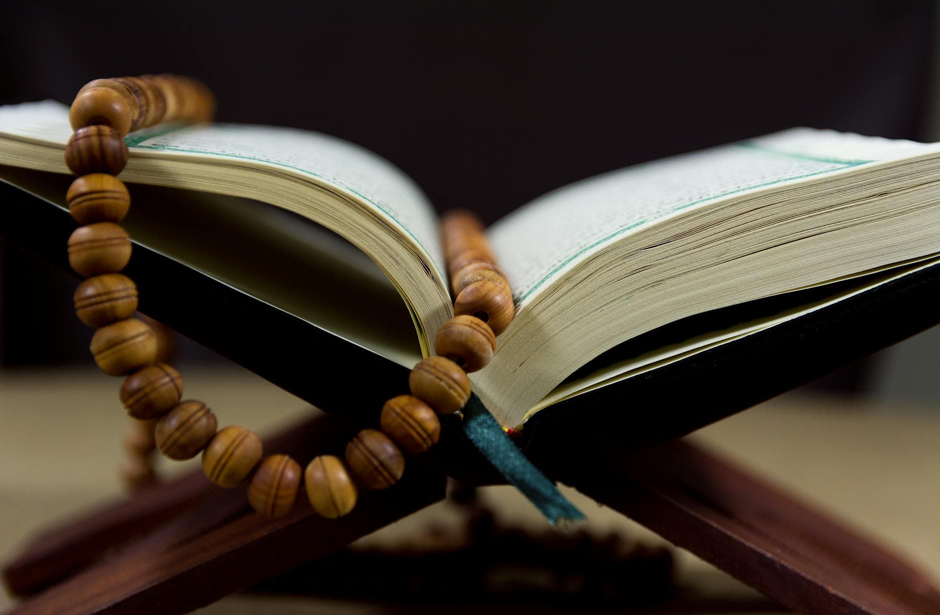 Photo by GR Stocks on Pexels An open Quran with prayer beads on a wooden stand, symbolizing faith and spirituality.