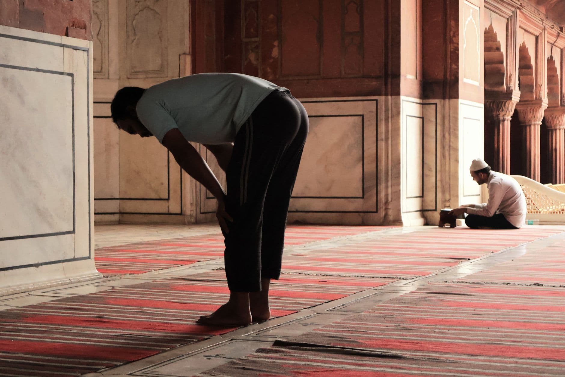 Photo by Sruthik Koneti on Pexels Two men praying inside the historic Jama Masjid in Delhi, India, highlighting spirituality and tradition.
