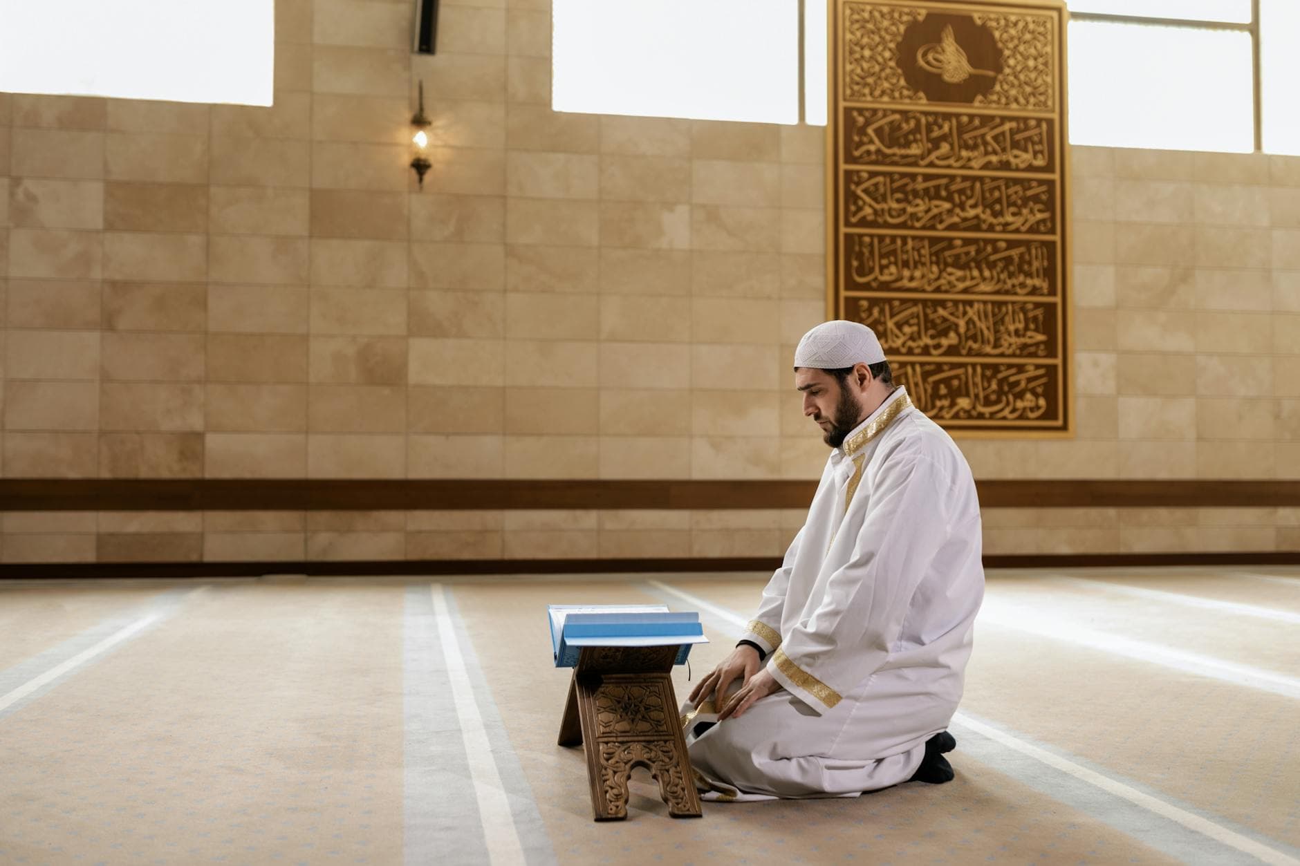 Photo by Alena Darmel on Pexels Man kneeling in prayer inside a mosque, wearing traditional Islamic clothing.